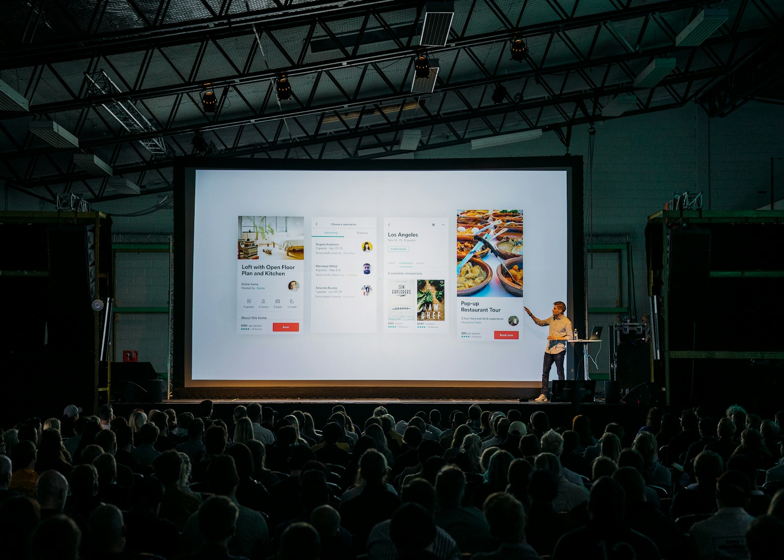 A presenter speaking to a large conference audience