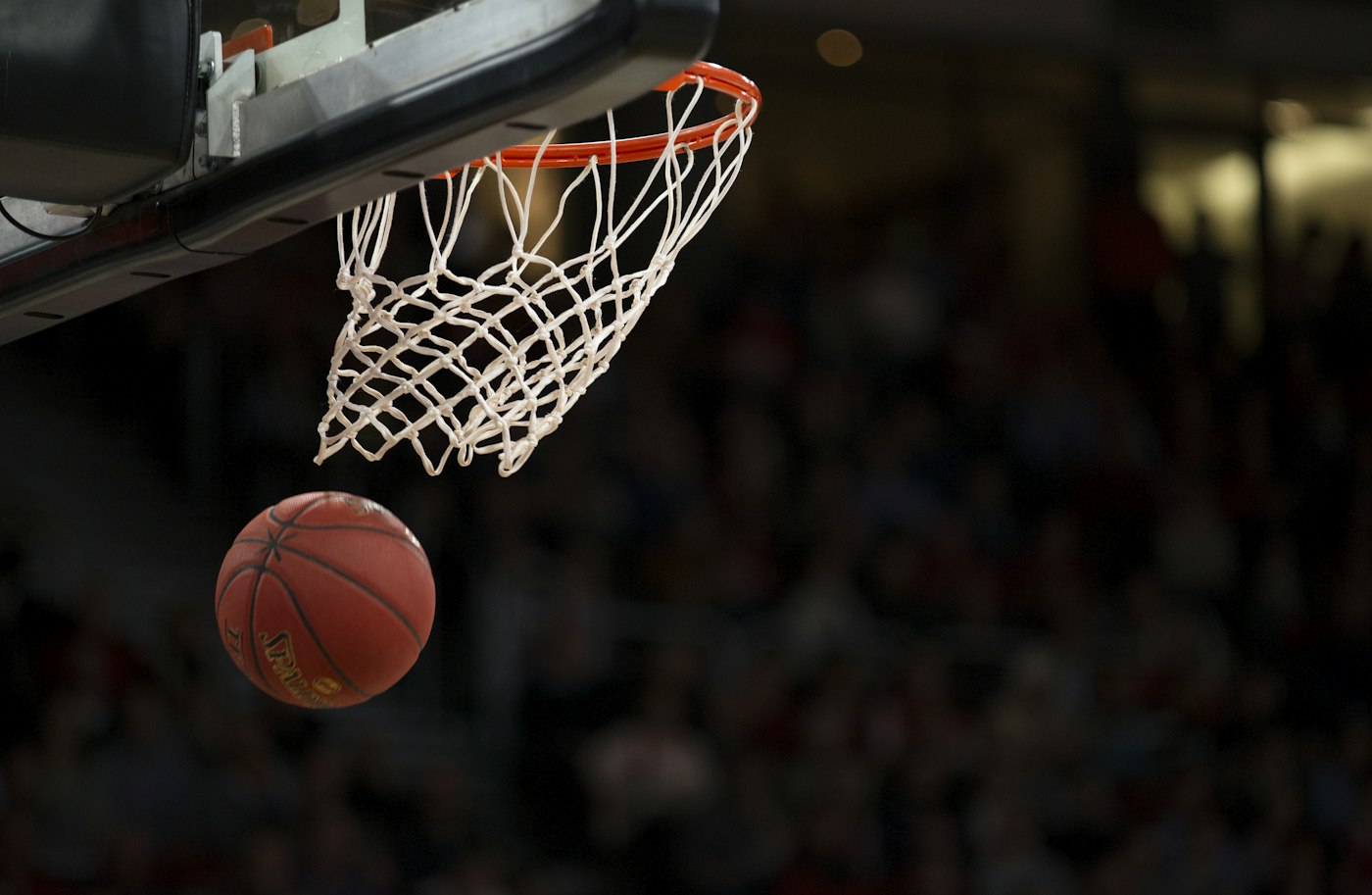A basketball player mid-game on an indoor court